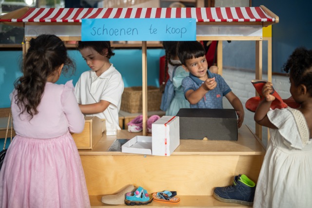 kinderen spelen in de themahoek schoenenwinkel
